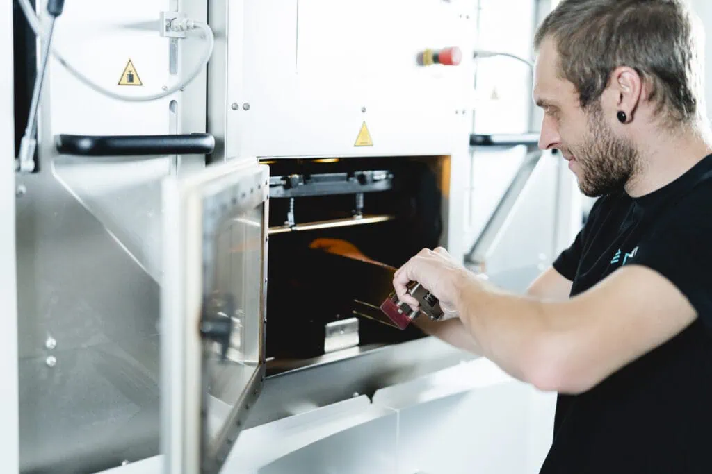 A prioadd employee replaces the coating blade of an EOS P396 SLS system.