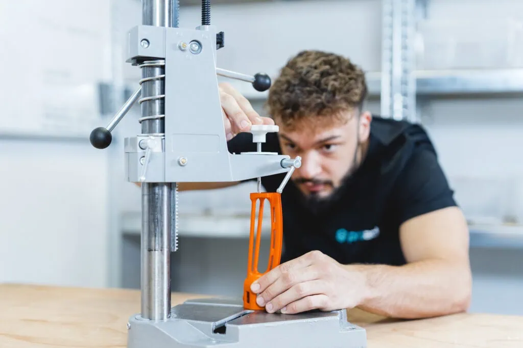 Un collaborateur de prioadd taraude un filetage M4 dans un composant d’impression 3D SLS