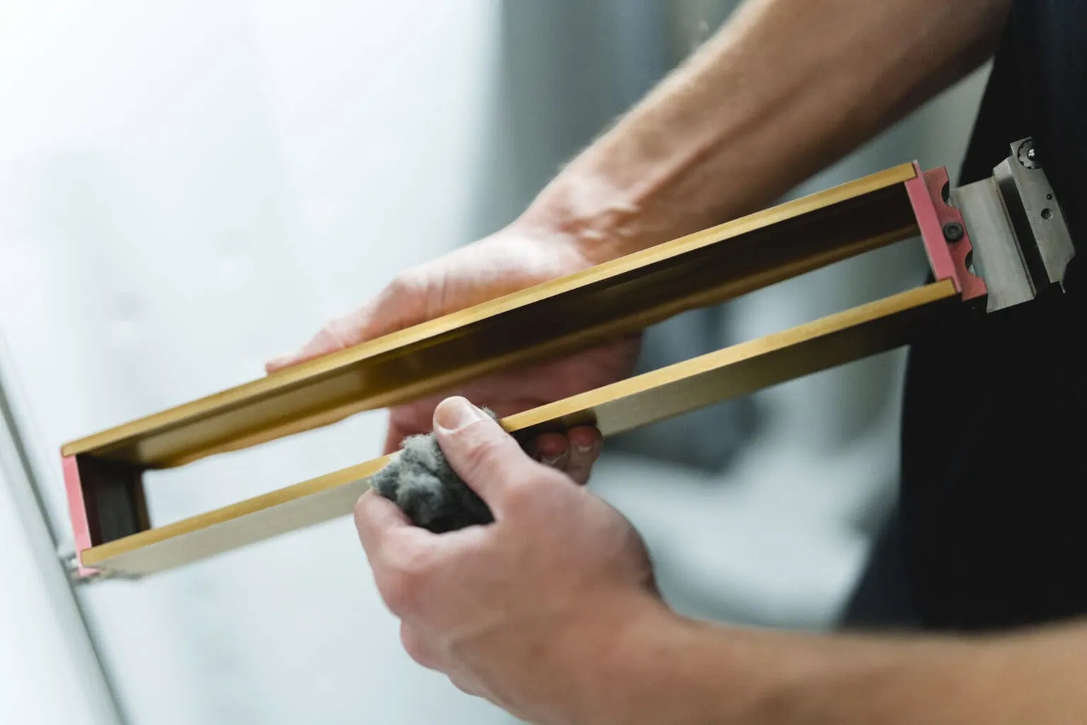 Un employé de prioadd nettoie une lame de revêtement d'une installation d'impression 3D SLS.