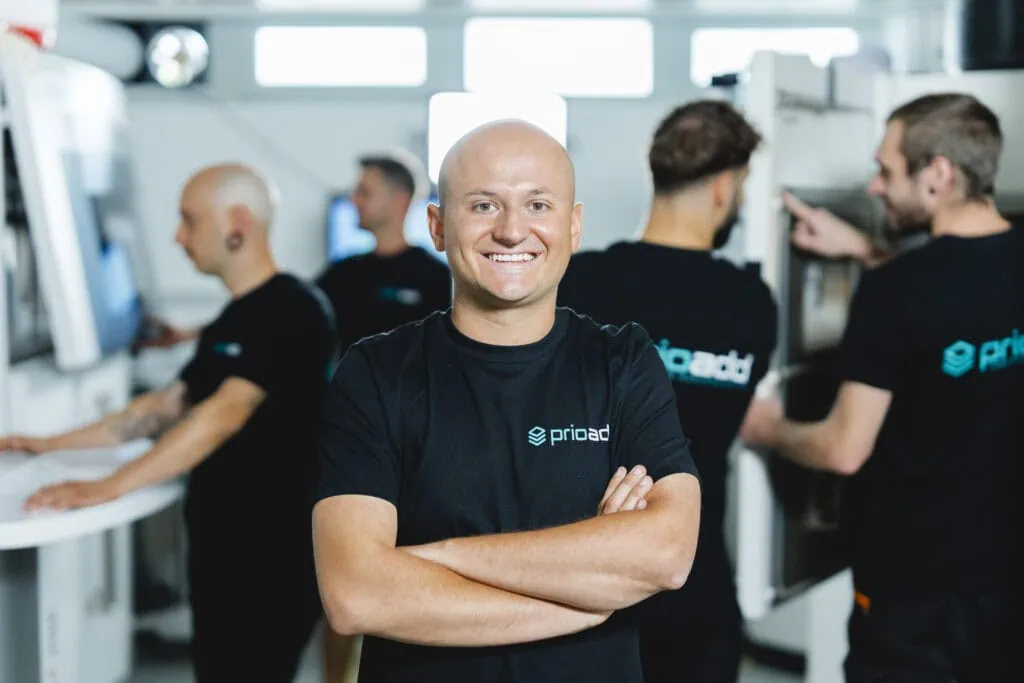 Des collaborateurs de prioadd travaillent sur des machines d’impression 3D SLS. Le gérant est au premier plan.