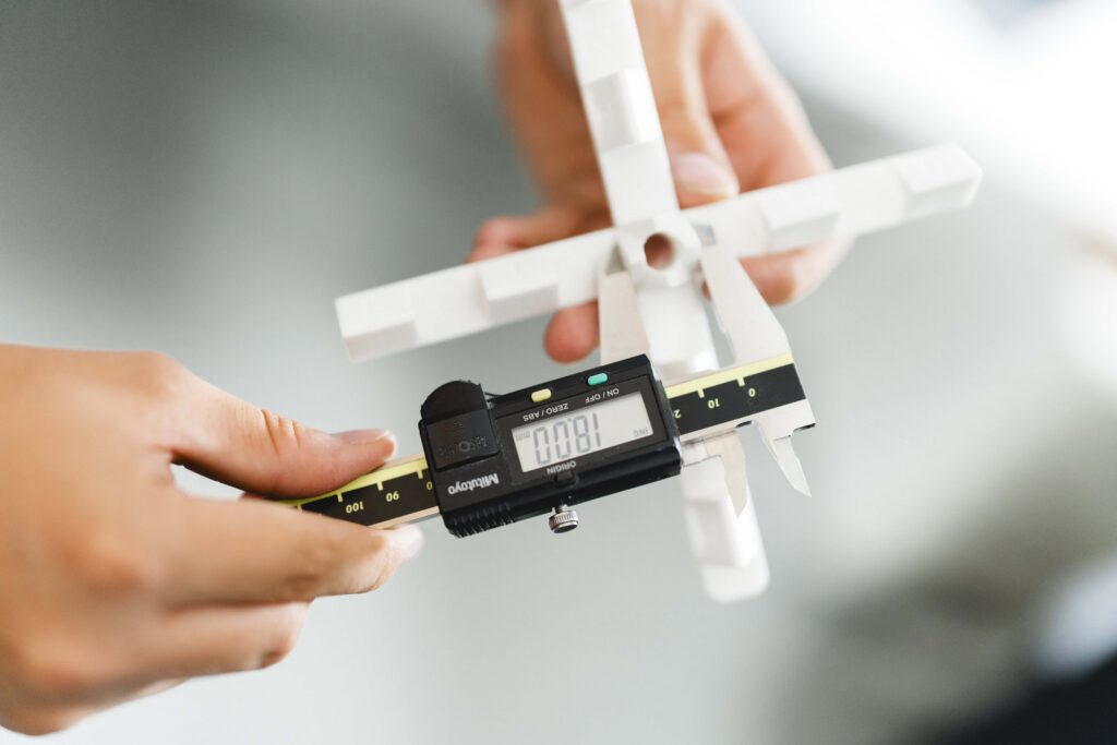 An SLS 3d printed calibration cross is measured in order to recalibrate the SLS machines.