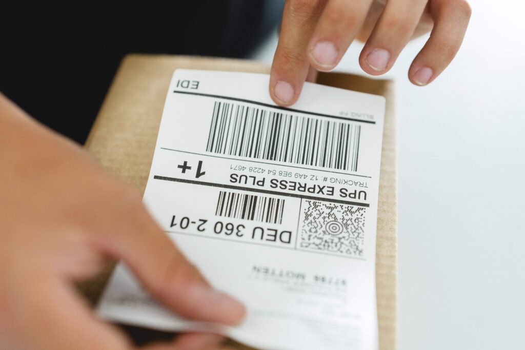 Mitarbeiter klebt UPS Express Plus Versandlabel auf ein Paket